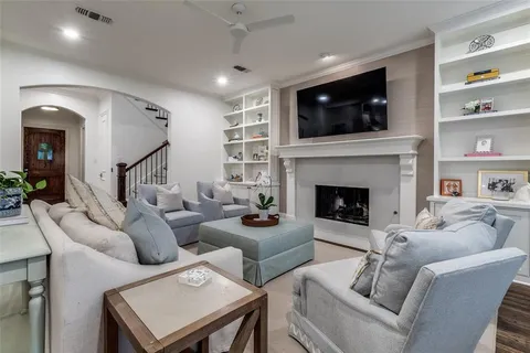 a living room with furniture a flat screen tv and a fireplace