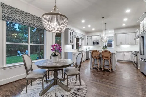 a dining room with furniture a chandelier and wooden floor