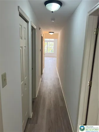 a view of a hallway with wooden floor and staircase