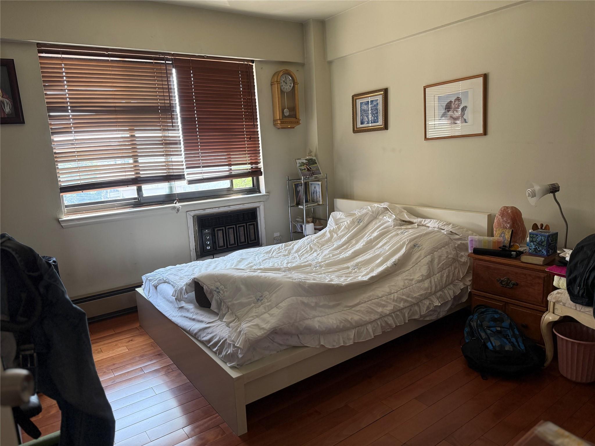 81-09 41st Avenue, Unit 5B Queens, NY 11373 - Photo 4 of 25 Bedroom with hardwood / wood-style floors and a baseboard heating unit