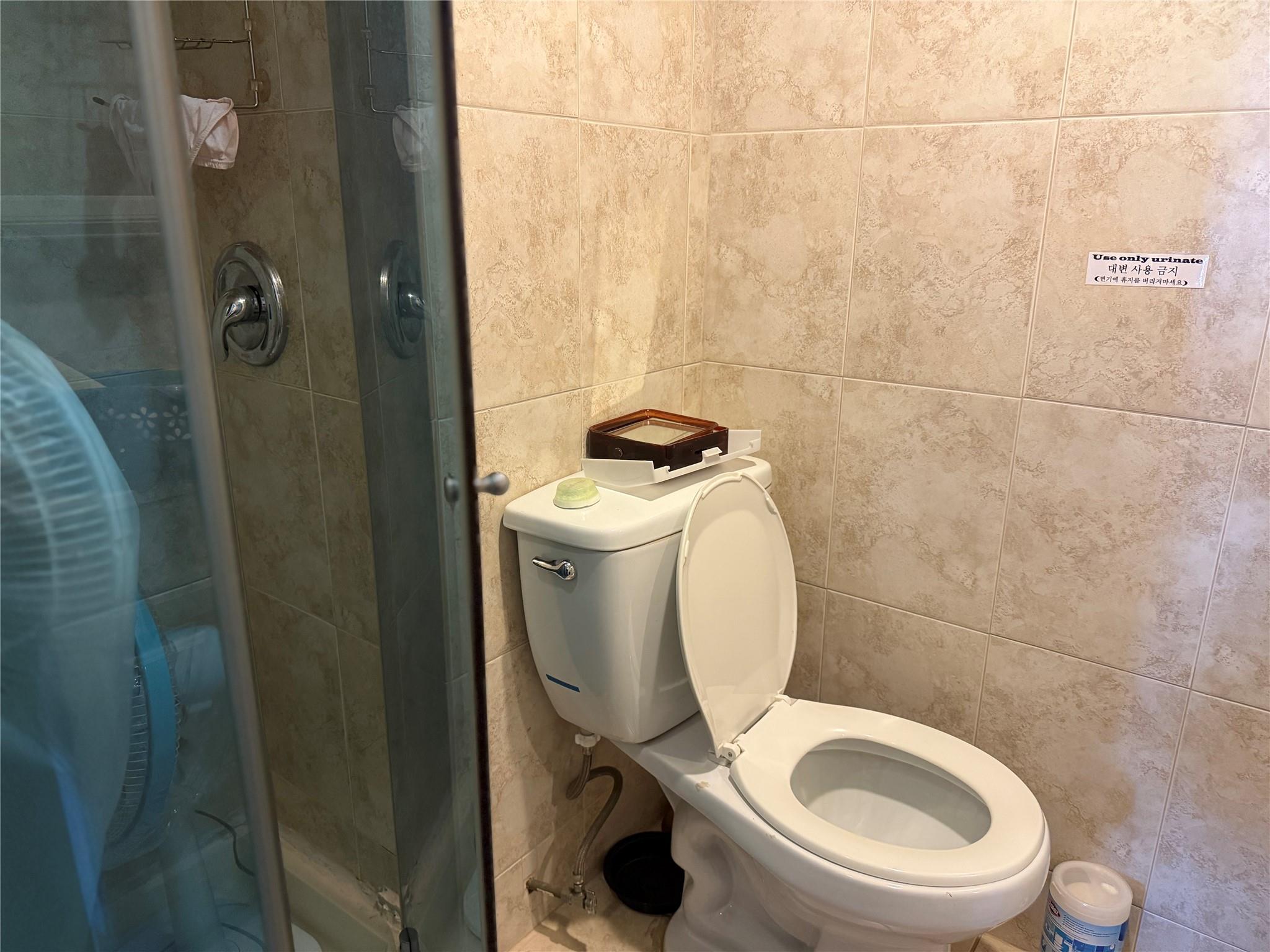 81-09 41st Avenue, Unit 5B Queens, NY 11373 - Photo 8 of 25 2nd bathroom inside master bedroom with tile walls, a shower stall, and toilet.