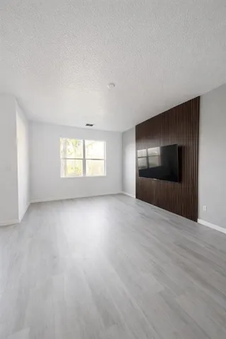 an empty room with windows and fireplace
