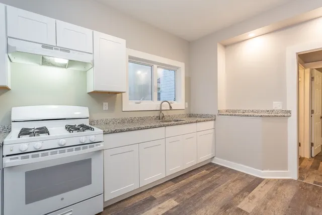 a kitchen with granite countertop white cabinets and white appliances