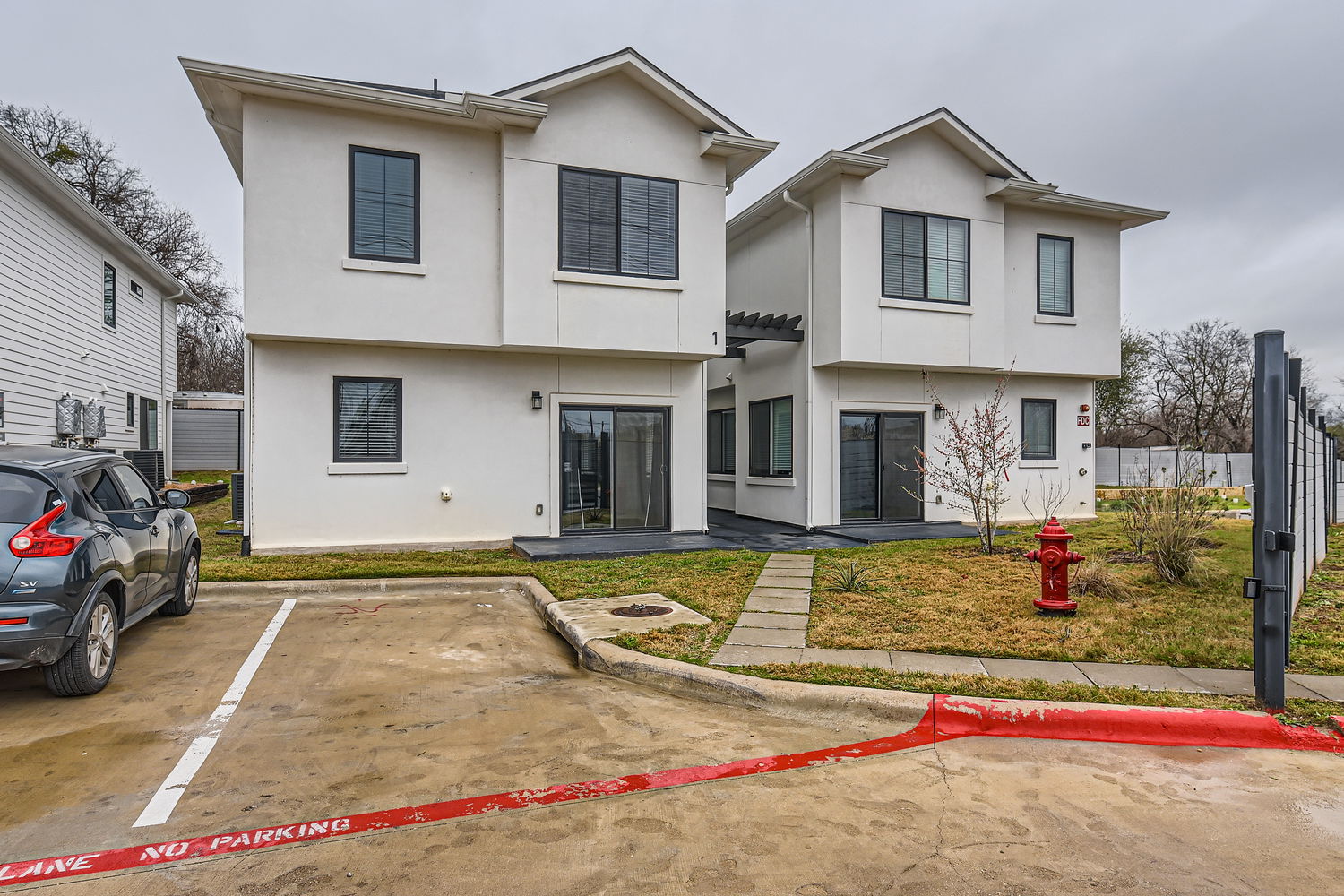 6820 Blue Dawn Trail, Unit 104 Austin, TX 78744 - Photo 1 of 1 a view of a white house with a small yard and large parking space