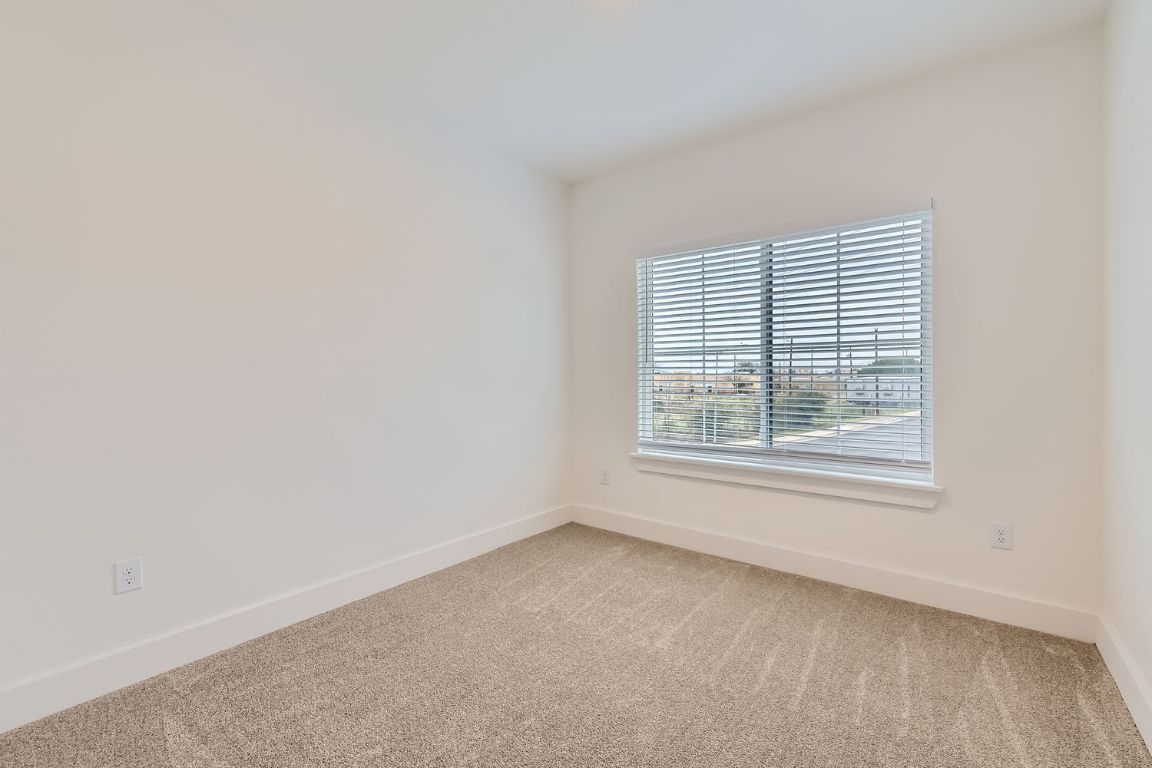6820 Blue Dawn Trail, Unit 104 Austin, TX 78744 - Photo 8 of 9 Carpeted spare room with baseboards