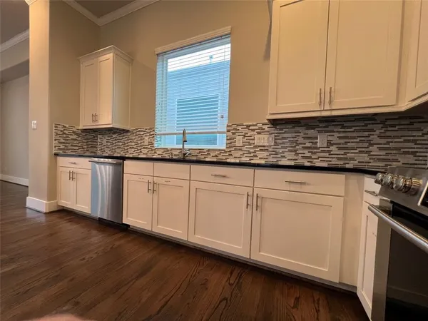 an empty room with ceiling fan and windows