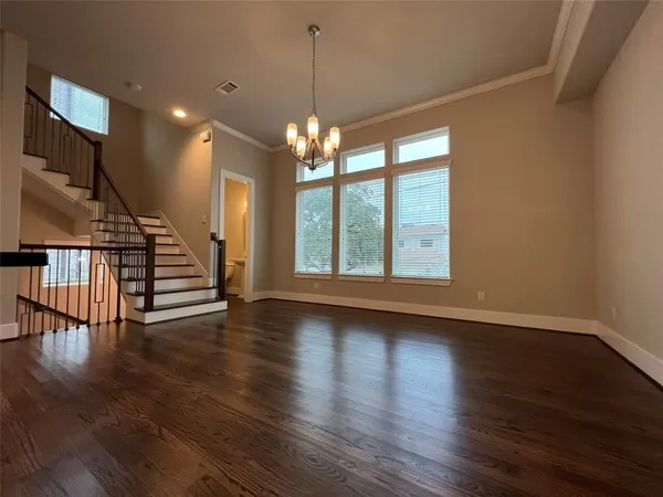 a large hall with kitchen island a large counter space a sink appliances and wooden floor