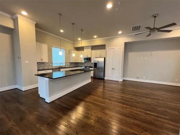 a large kitchen with granite countertop a stove and cabinets