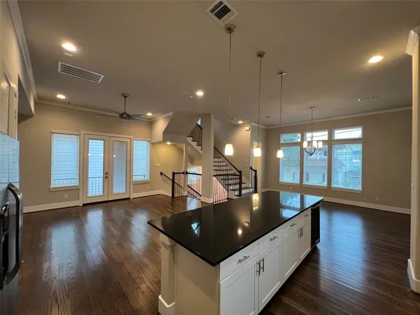 a kitchen with granite countertop white cabinets and a stove top oven