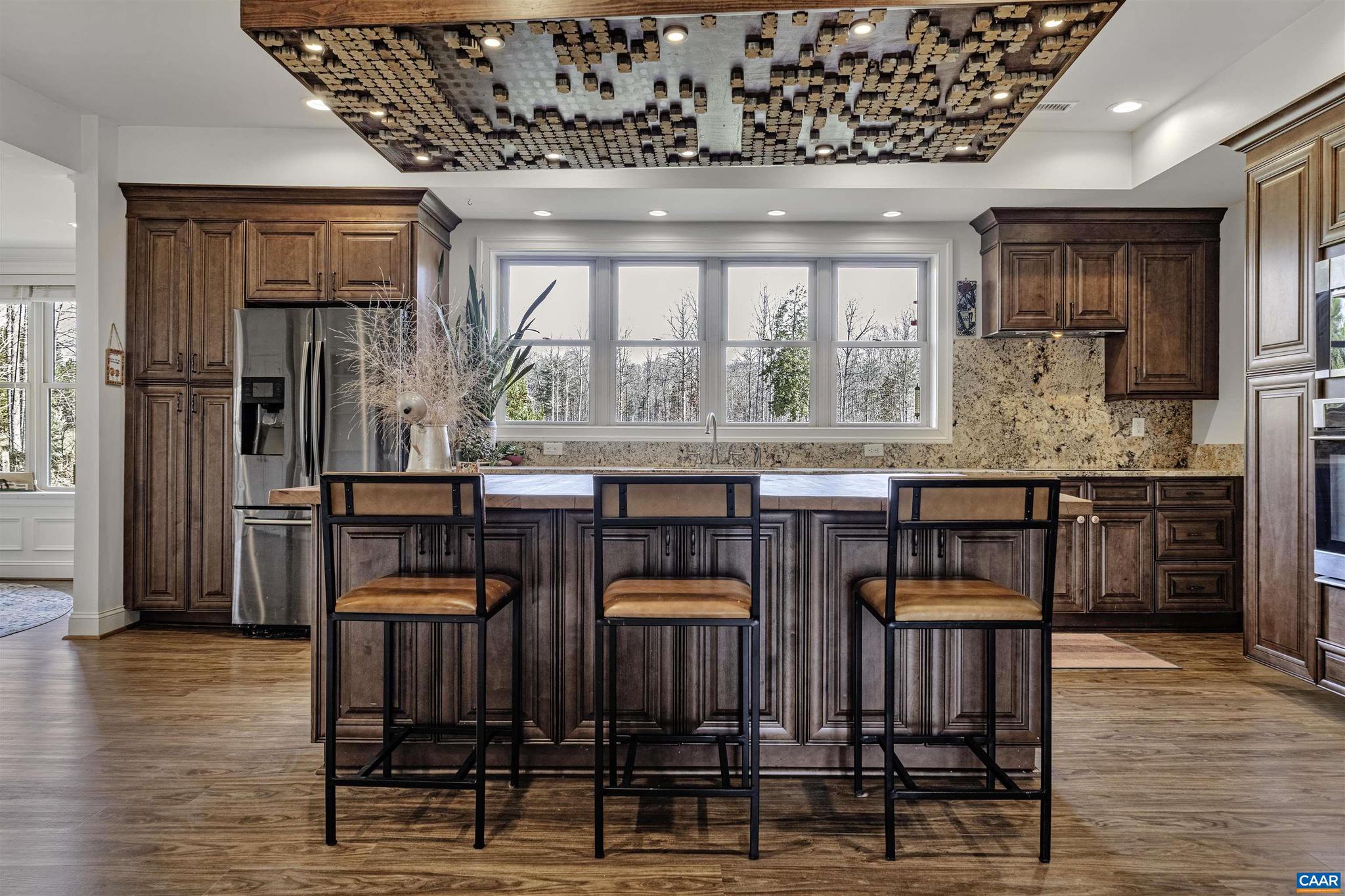 4337 Riddles Bridge Road Goochland, VA 23063 - Photo 5 of 43 a kitchen with granite countertop a stove a sink dishwasher a dining table and chairs with wooden floor