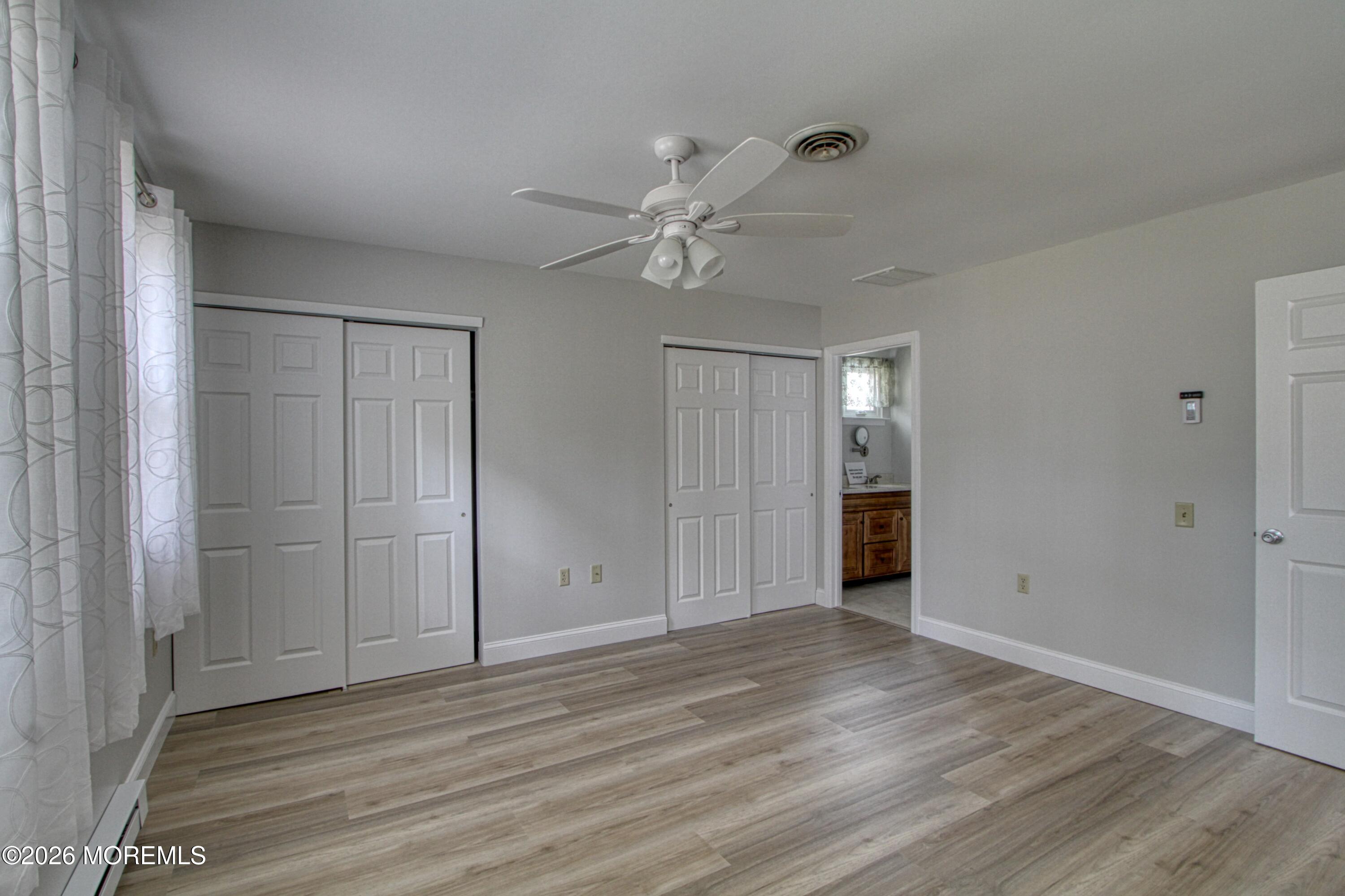 a view of an empty room with wooden floor