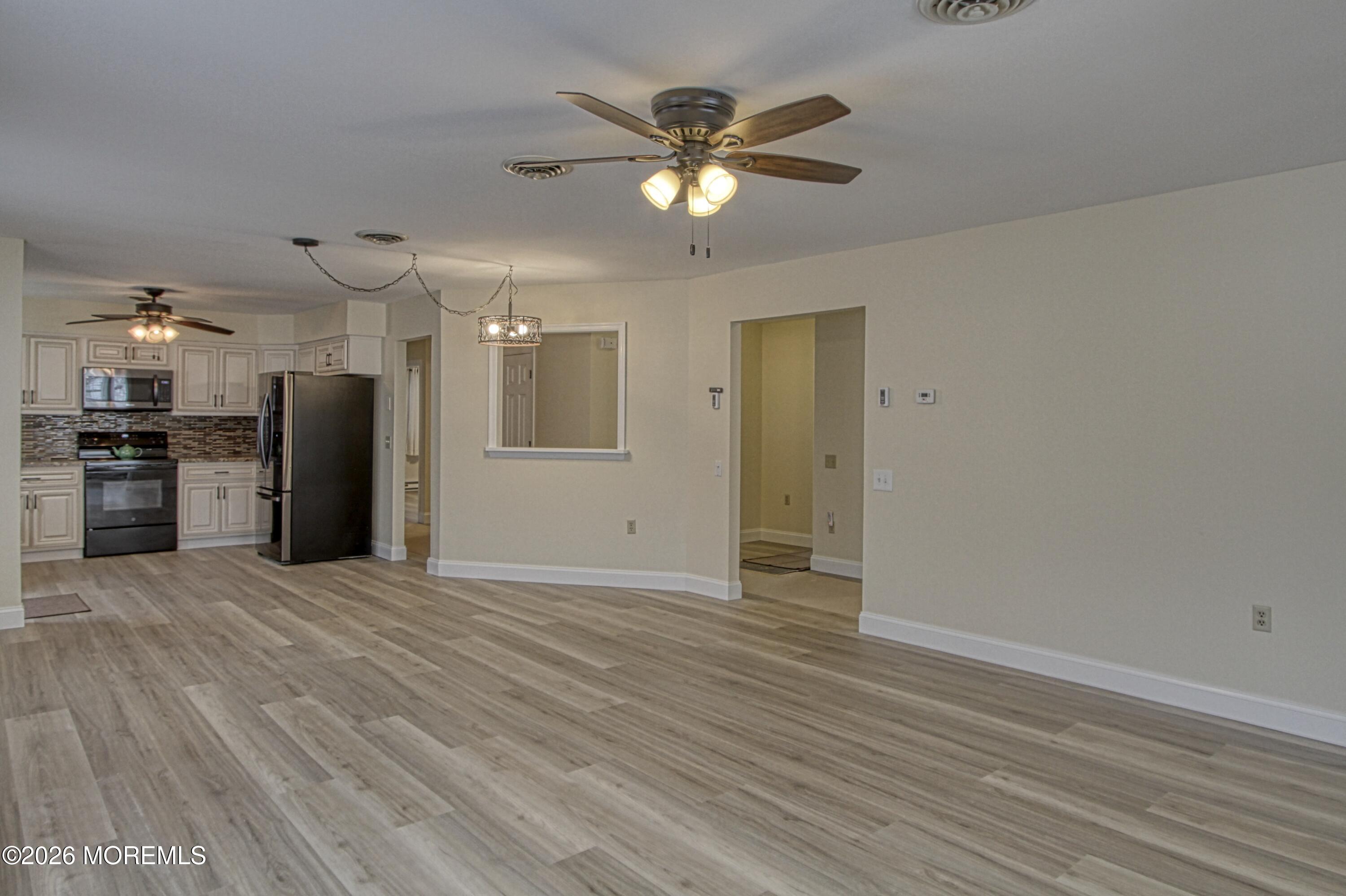 111 Sunset Road, Unit 60 Whiting, NJ 08759 - Photo 20 of 23 a view of an empty room with wooden floor and a ceiling fan