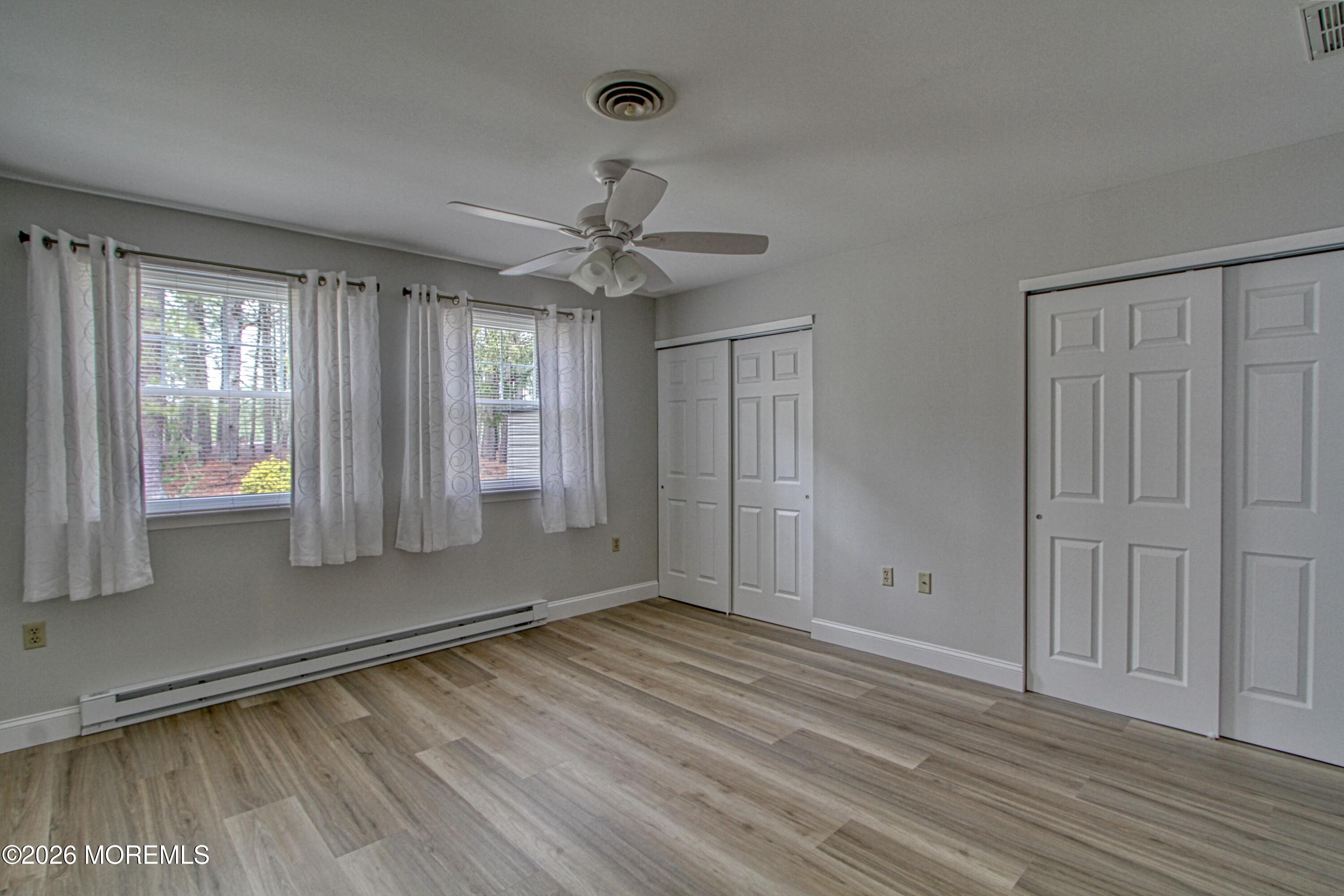 111 Sunset Road, Unit 60 Whiting, NJ 08759 - Photo 22 of 23 an empty room with wooden floor and windows