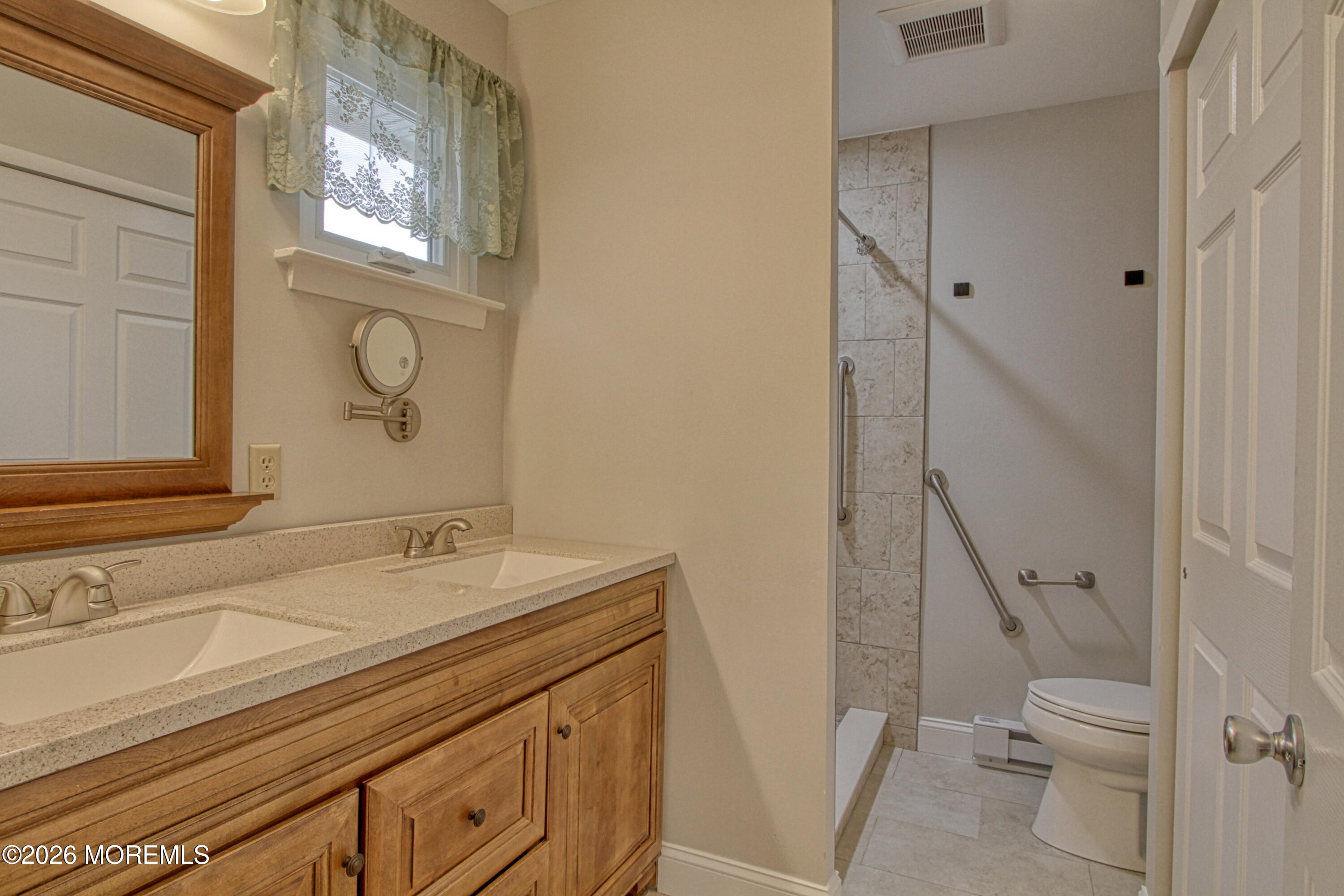 111 Sunset Road, Unit 60 Whiting, NJ 08759 - Photo 23 of 23 a bathroom with a sink a toilet and a mirror