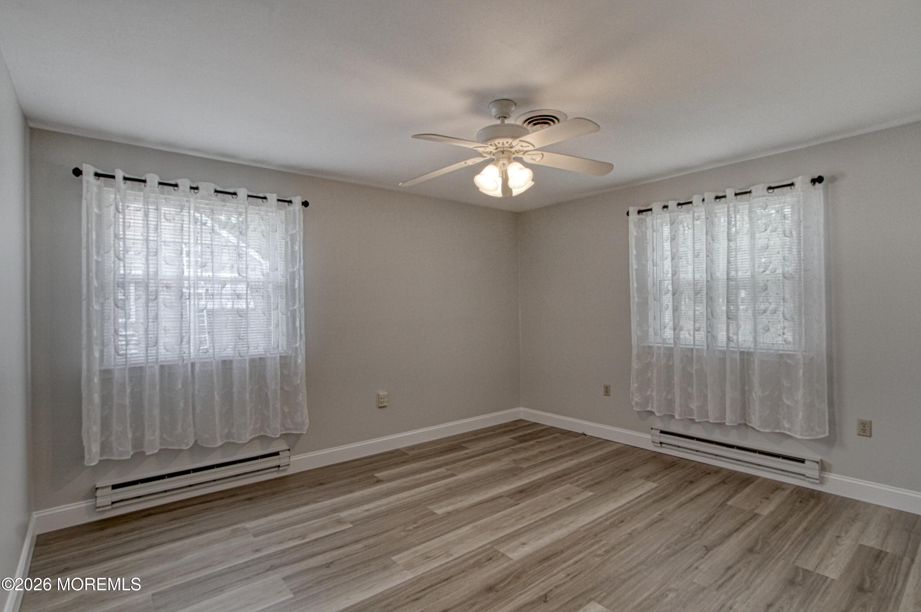 111 Sunset Road, Unit 60 Whiting, NJ 08759 - Photo 3 of 23 an empty room with wooden floor fan and windows