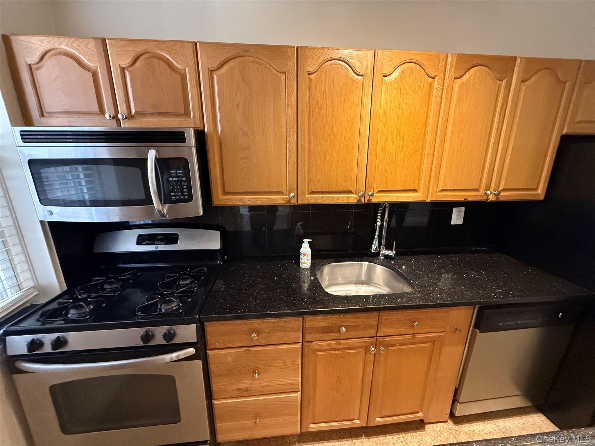 796 Bronx River Road, Unit B38 Bronxville, NY 10708 - Photo 2 of 31 a kitchen with granite countertop wood cabinets stainless steel appliances and a sink