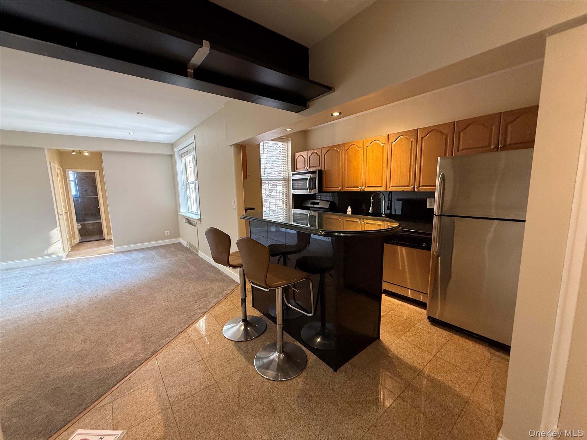 796 Bronx River Road, Unit B38 Bronxville, NY 10708 - Photo 3 of 31 a kitchen with a table chairs refrigerator and cabinets
