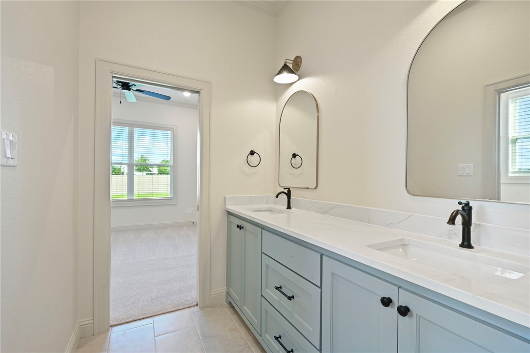 7052 Skipping Rock Path Bryan, TX 77808 - Photo 19 of 23 a bathroom with a double vanity sink and mirror