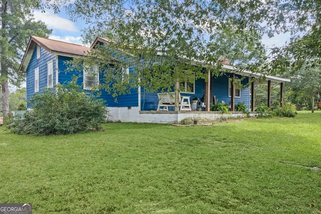 a view of a house with a yard and porch