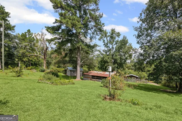 a aerial view of a house with swimming pool next to a big yard