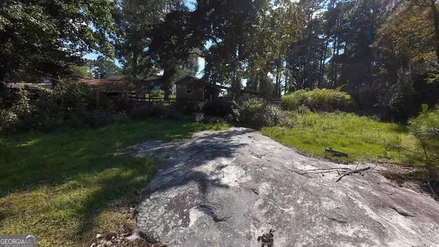 an aerial view of residential house with outdoor space and trees all around