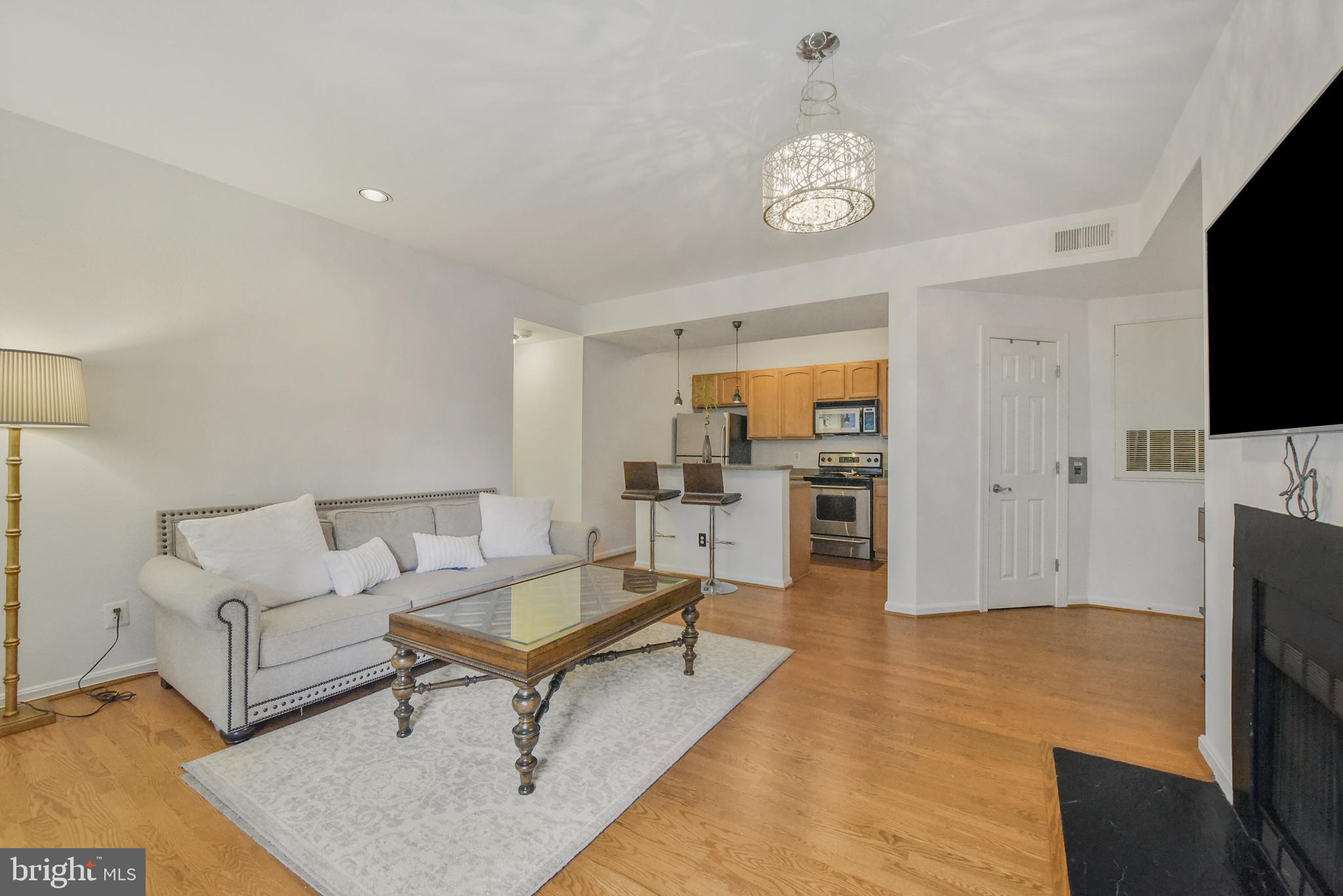3909 Penderview Drive, Unit 1923 Fairfax, VA 22033 - Photo 4 of 19 a living room with furniture a rug and a flat screen tv