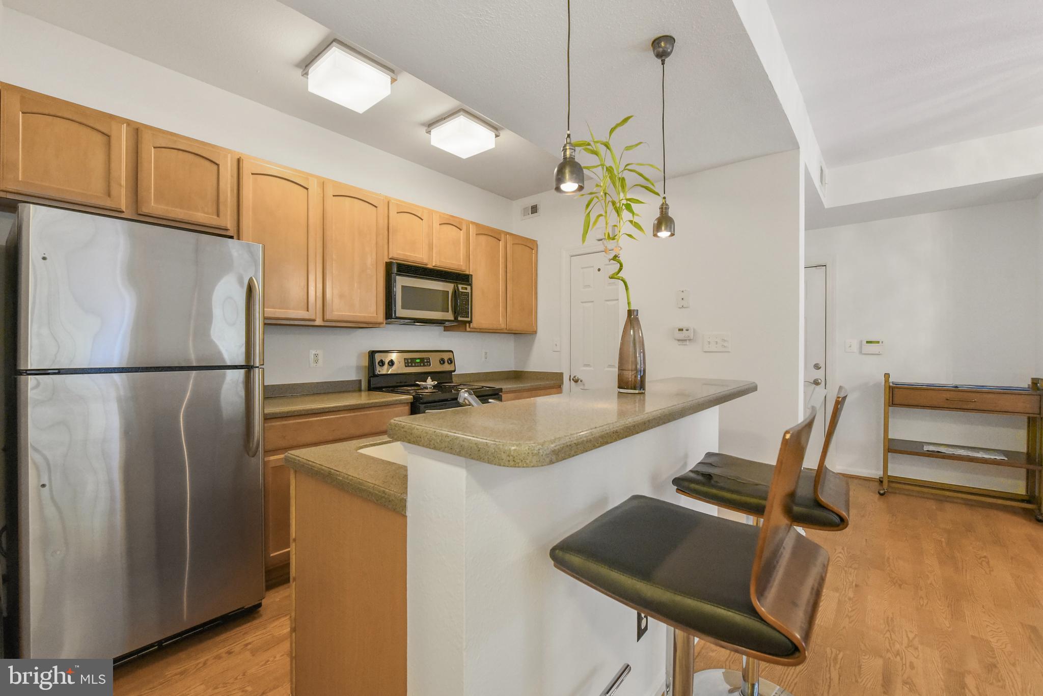 3909 Penderview Drive, Unit 1923 Fairfax, VA 22033 - Photo 9 of 19 a kitchen with stainless steel appliances granite countertop a sink refrigerator stove and microwave