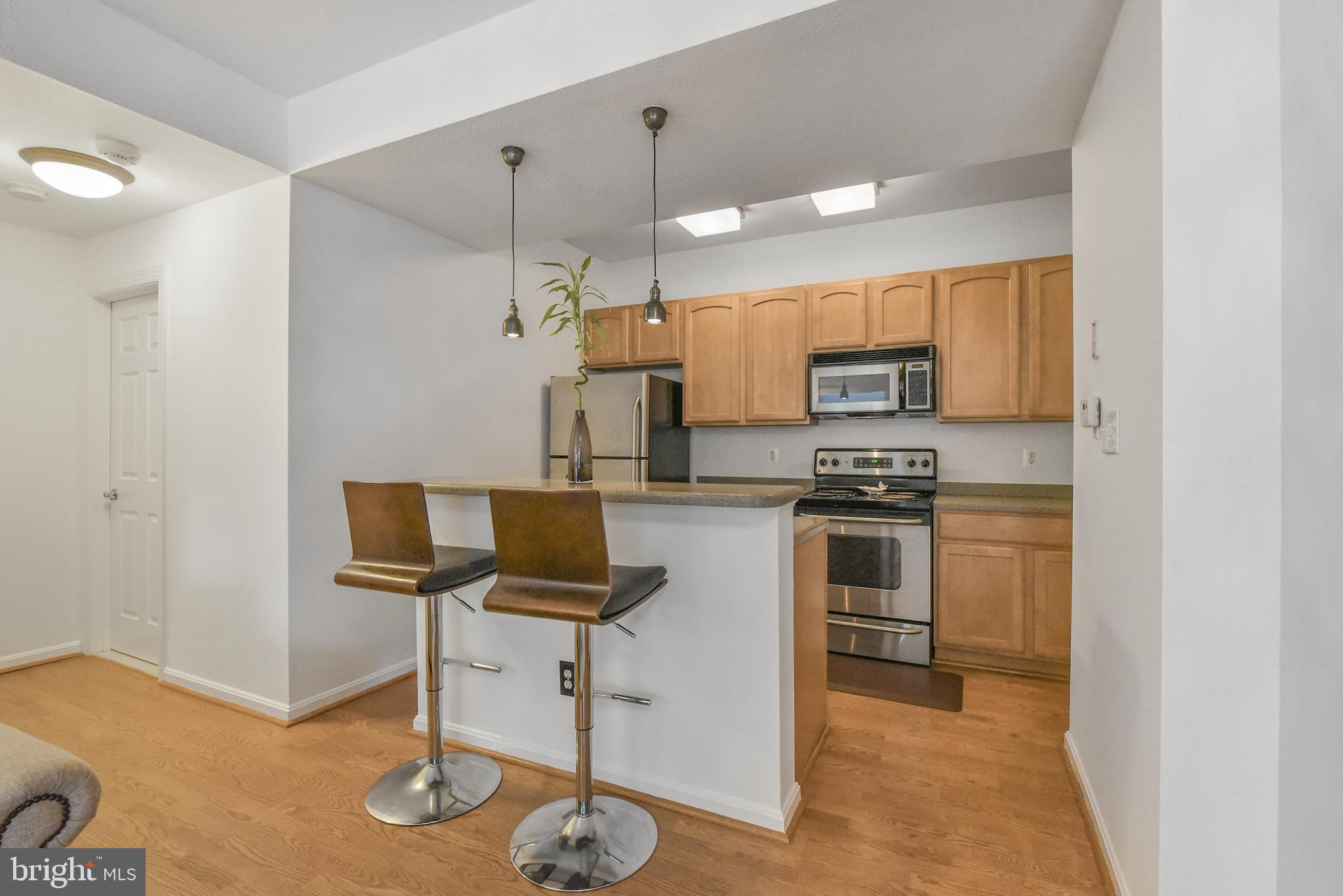 3909 Penderview Drive, Unit 1923 Fairfax, VA 22033 - Photo 10 of 19 a kitchen with stainless steel appliances kitchen island granite countertop a stove a sink and a refrigerator