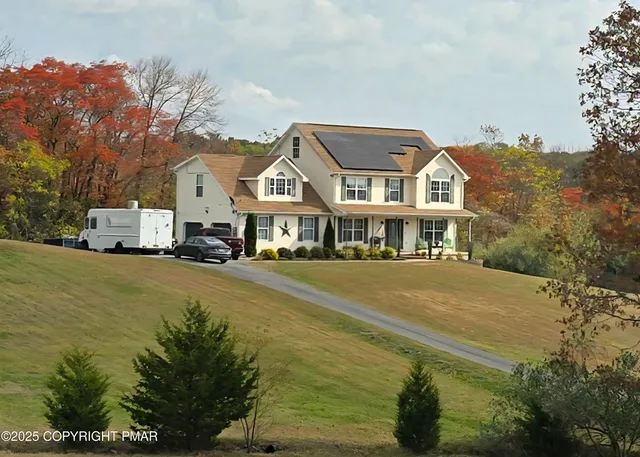 a front view of a building with a garden and trees