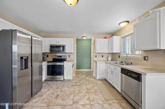 a large kitchen with cabinets stainless steel appliances and a counter space
