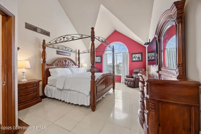 a bedroom with bed and a large mirror