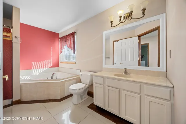 a bathroom with a granite countertop toilet sink and mirror