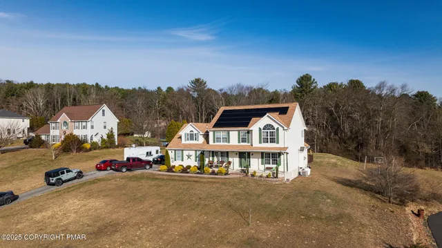 a front view of a house with swimming pool and trees