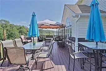 a view of deck with furniture and umbrella
