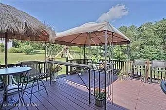 a view of a patio with a table and chairs under an umbrella with wooden floor