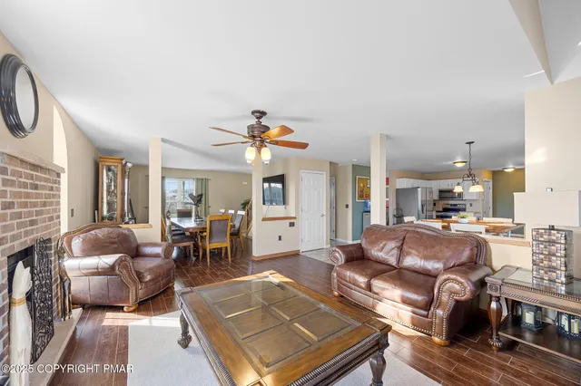 a living room with furniture a dining table and chairs with wooden floor