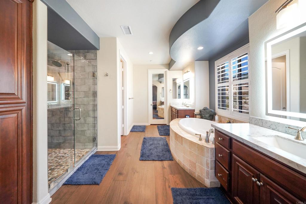 22963 Stokes Road Ramona, CA 92065 - Photo 31 of 57 a large spacious bathroom with a double vanity sink a large mirror and shower