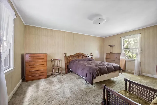 a spacious bedroom with a bed and wooden floor