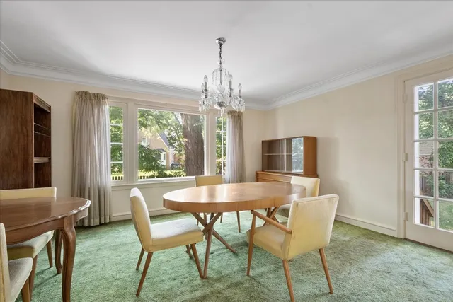 a dining room with furniture a chandelier and wooden floor