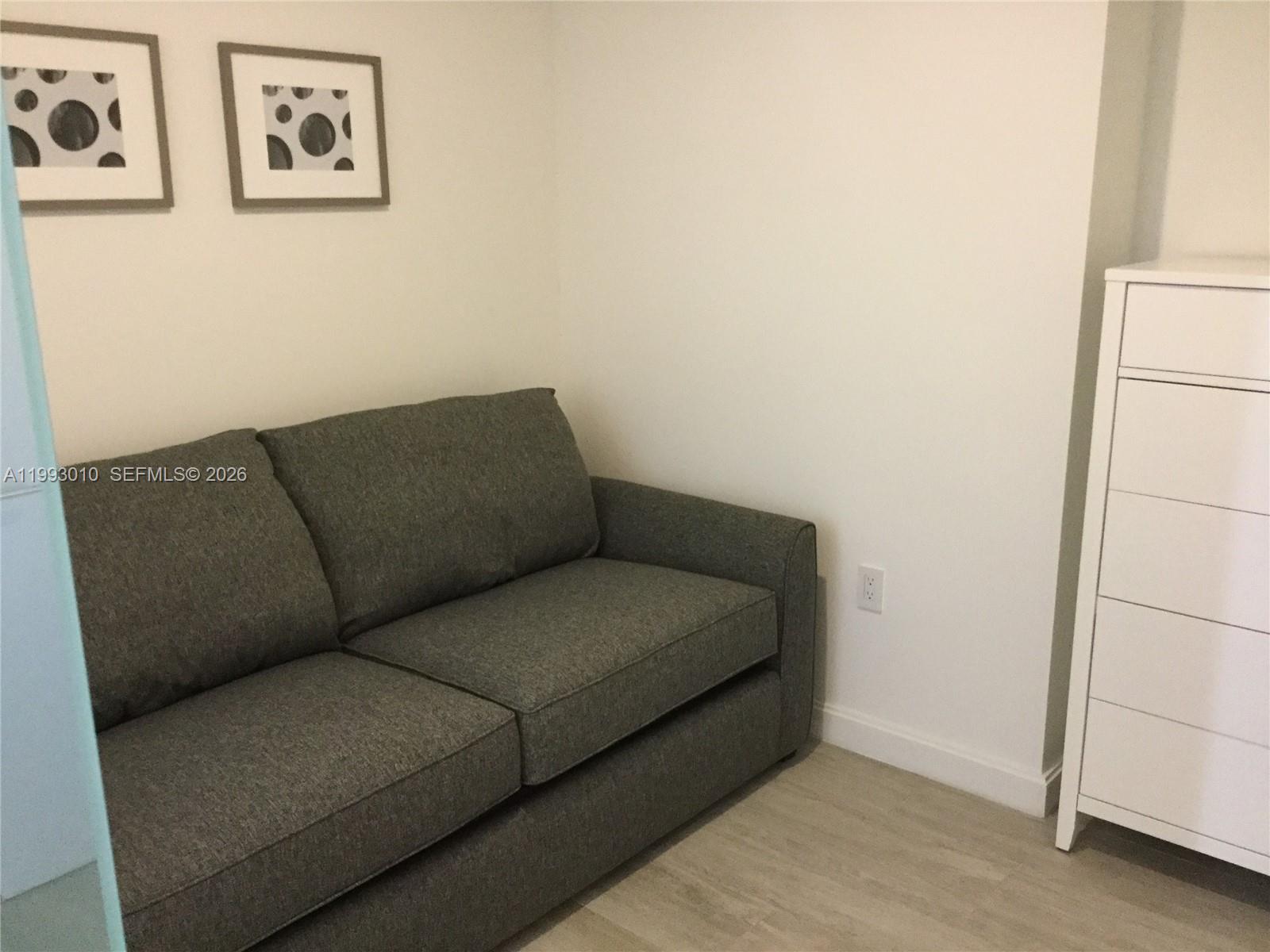 55 Southwest 9th Street, Unit 1905 Miami, FL 33130 - Photo 13 of 19 a living room with furniture and a wall