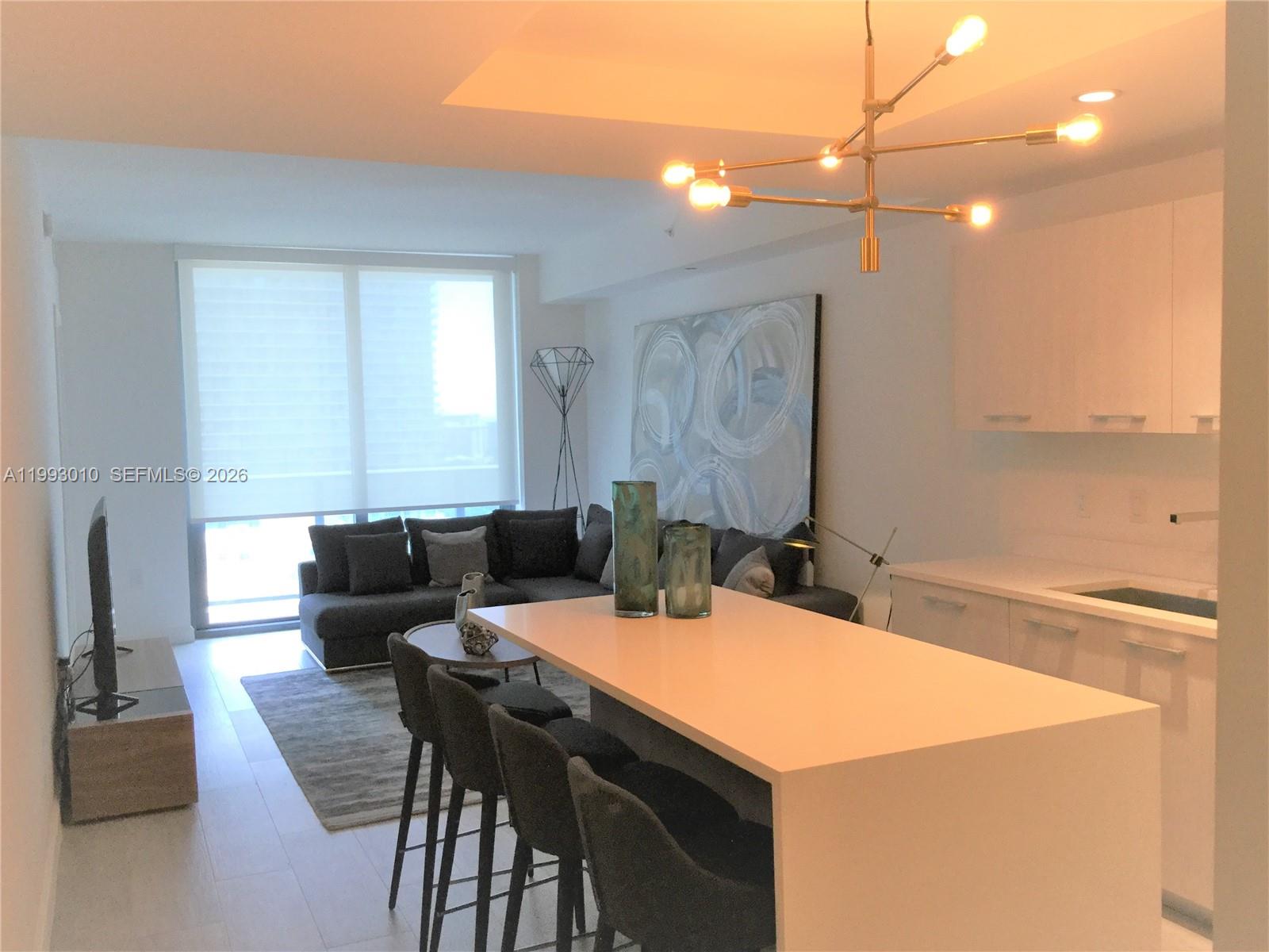 55 Southwest 9th Street, Unit 1905 Miami, FL 33130 - Photo 5 of 19 a view of a dining room with furniture and a chandelier
