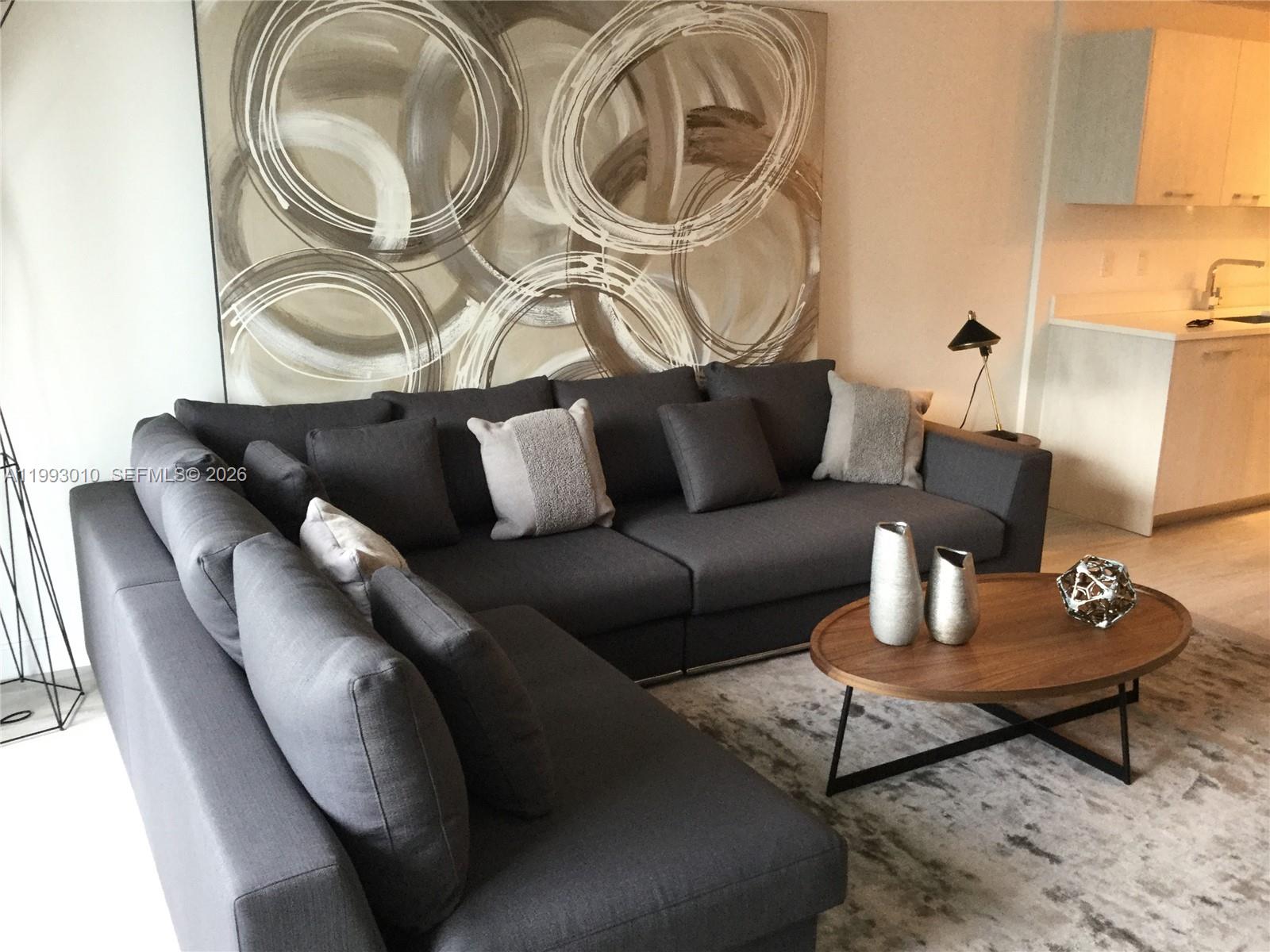 55 Southwest 9th Street, Unit 1905 Miami, FL 33130 - Photo 7 of 19 a living room with furniture and a wooden floor