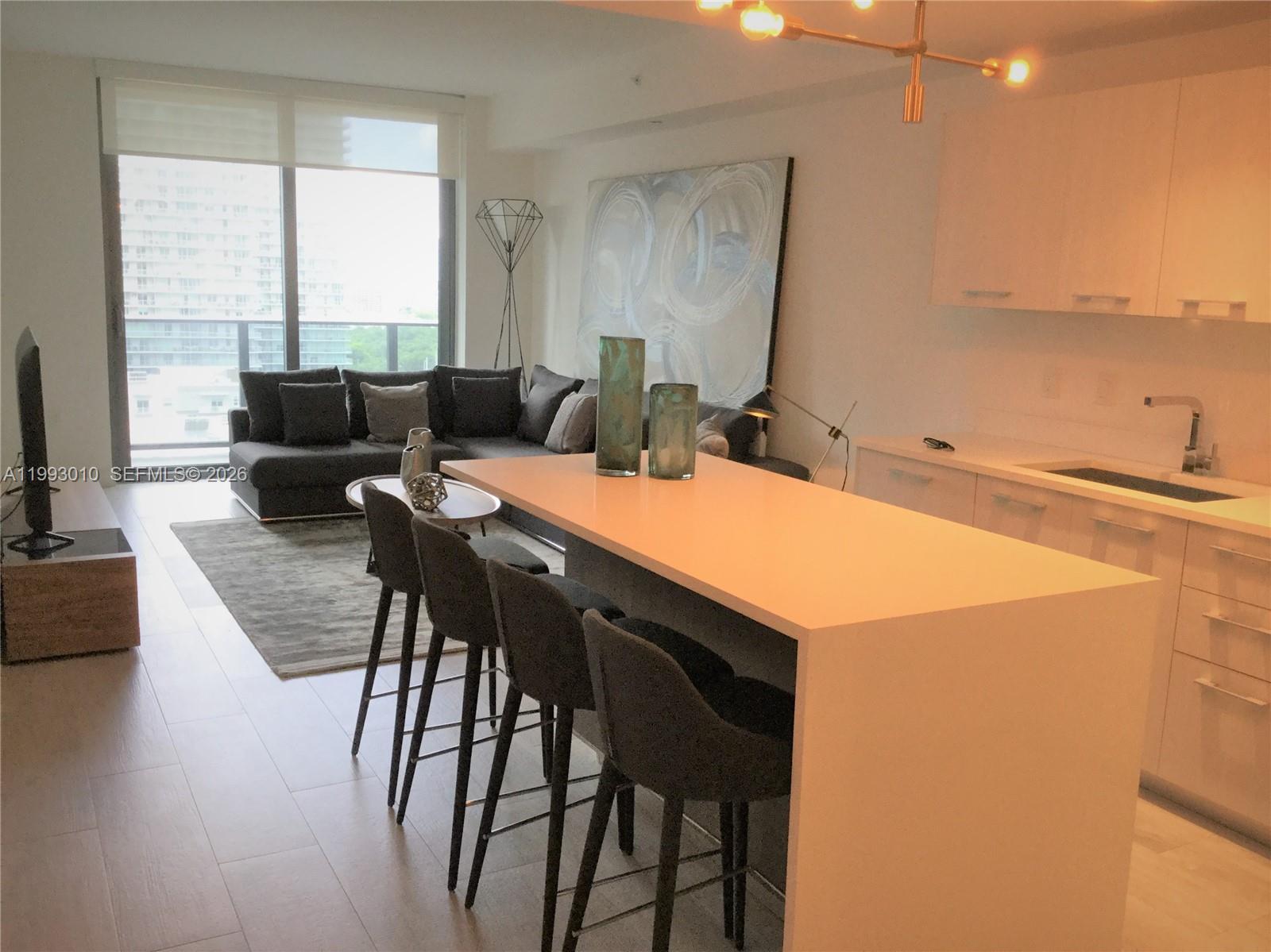 55 Southwest 9th Street, Unit 1905 Miami, FL 33130 - Photo 9 of 19 a view of a dining room with furniture and wooden floor