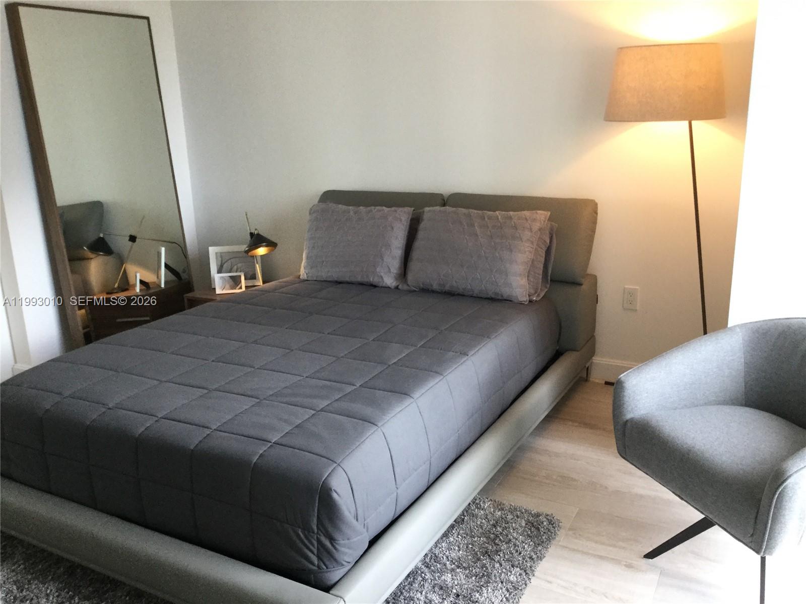 55 Southwest 9th Street, Unit 1905 Miami, FL 33130 - Photo 10 of 19 a bedroom with a bed and lamp
