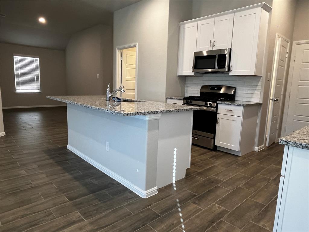 409 Wydown Drive Princeton, TX 75407 - Photo 13 of 29 a kitchen with stainless steel appliances a sink a stove a microwave a sink a refrigerator and window