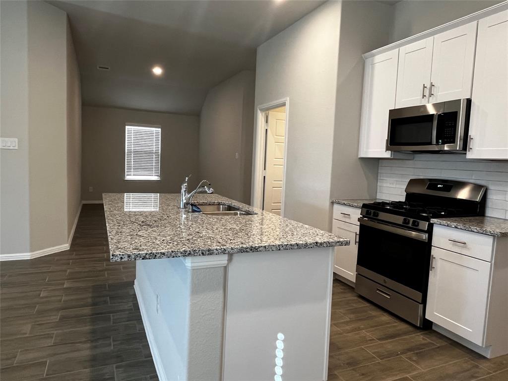409 Wydown Drive Princeton, TX 75407 - Photo 14 of 29 a kitchen with stainless steel appliances granite countertop a sink and a stove