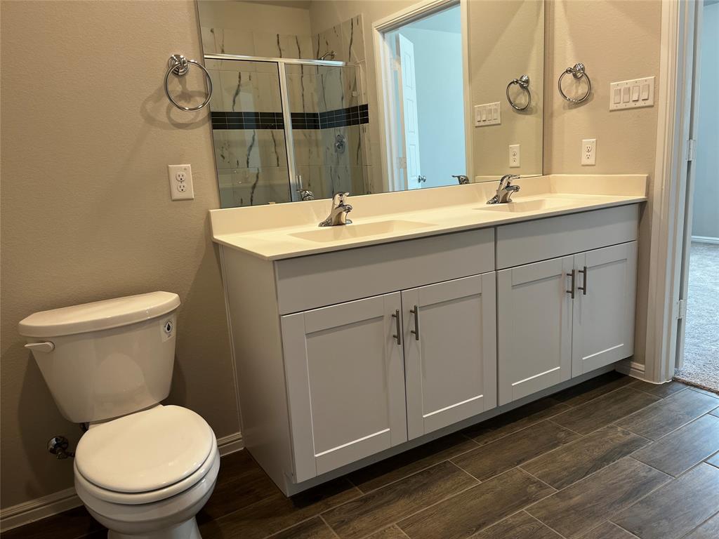 409 Wydown Drive Princeton, TX 75407 - Photo 25 of 29 a bathroom with a toilet a sink and mirror