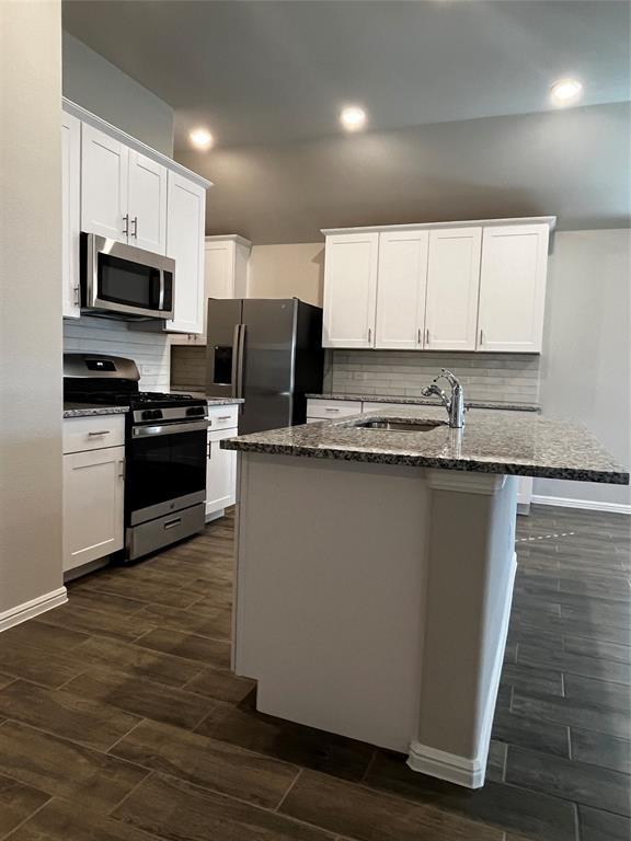409 Wydown Drive Princeton, TX 75407 - Photo 10 of 29 a kitchen with stainless steel appliances granite countertop a refrigerator a stove top oven a sink and dishwasher with wooden floor