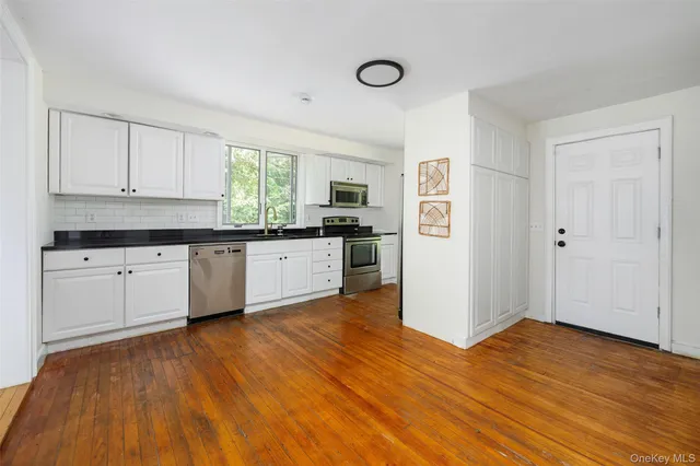a kitchen with granite countertop a stove and cabinets