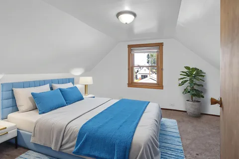 a bedroom with a large bed and potted plant